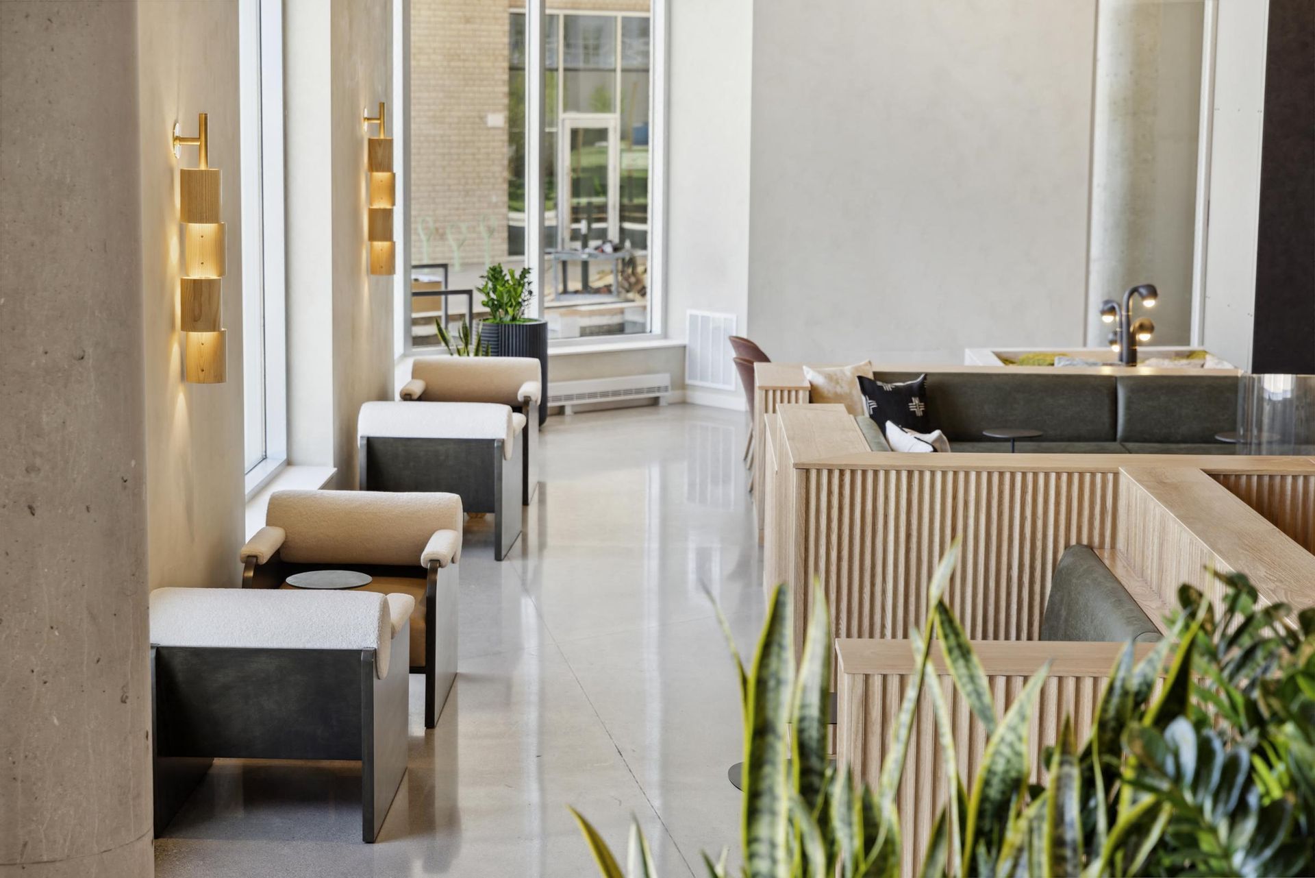 Bright apartment lobby with beige seating, plants, and natural light at Esox House in St. Paul, MN.