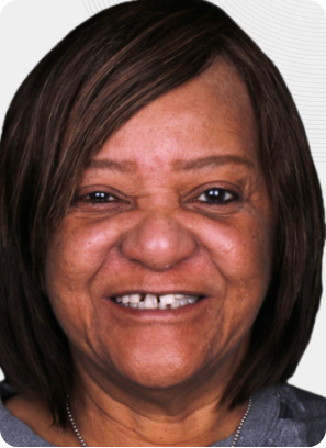Woman with short brown hair smiles, showing her teeth.