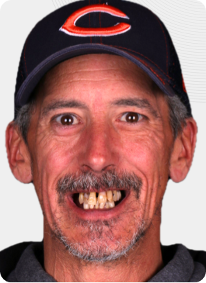 Man wearing a navy Chicago Bears hat, smiling with visible teeth.