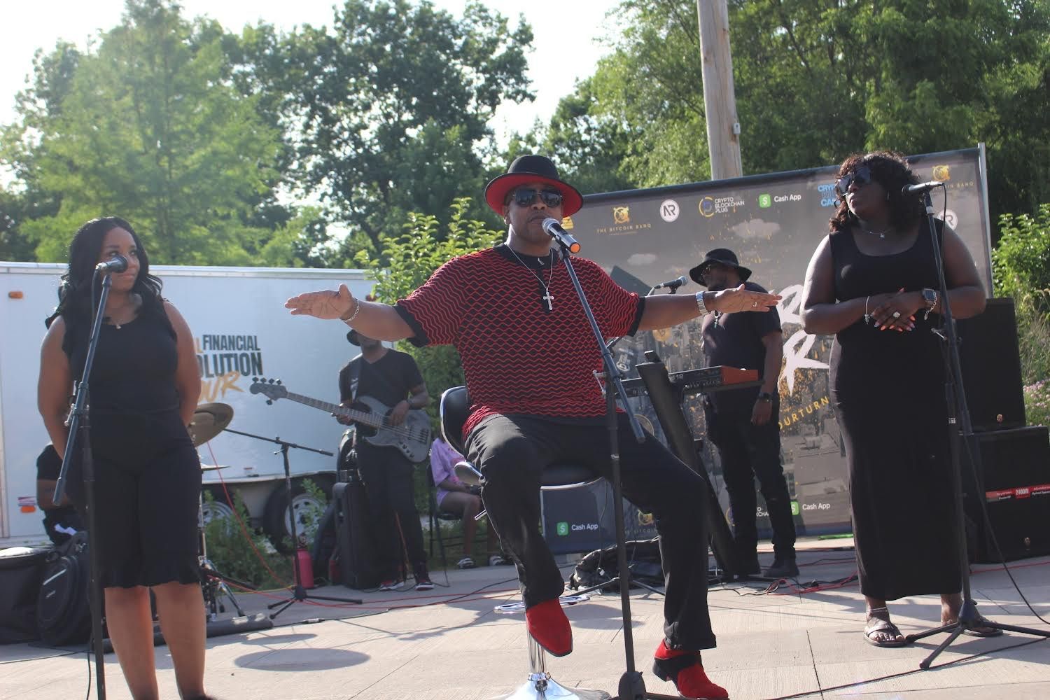 A man is sitting on a stool in front of a microphone on a stage.