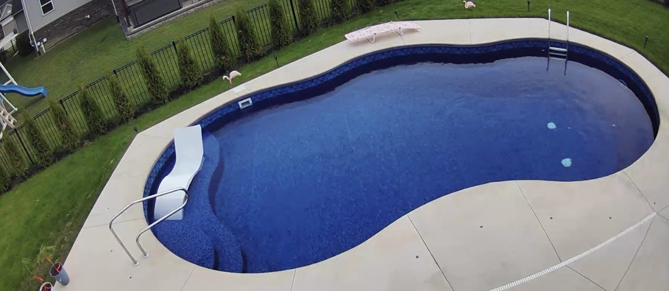 An aerial view of a large swimming pool in a backyard.