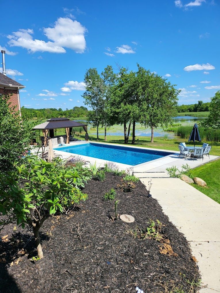 There is a large swimming pool in the backyard of a house.