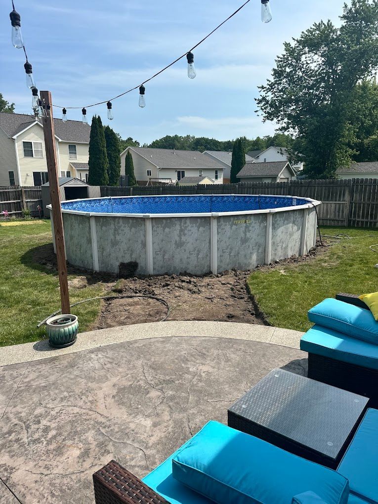 A large swimming pool is sitting in the middle of a backyard.