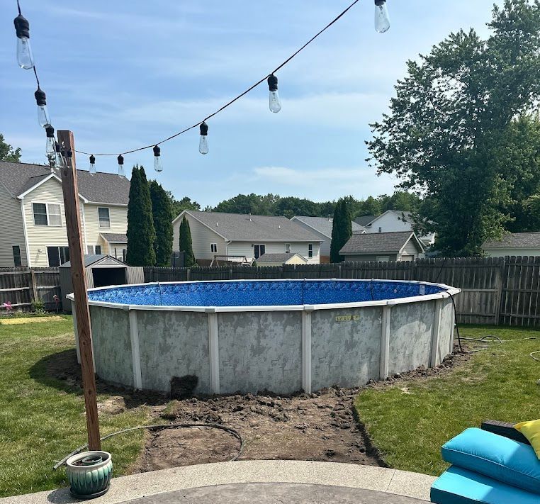 A large swimming pool is being built in a backyard.