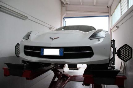 Un'auto sportiva bianca è su un ascensore in un garage