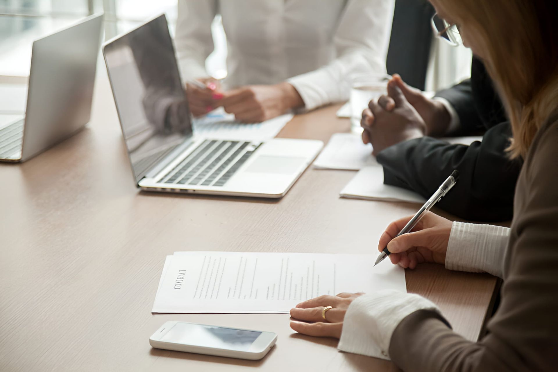 A Group Of People Are Sitting At A Table With Laptops And Papers — De Silva Hebron In Darwin City, NT