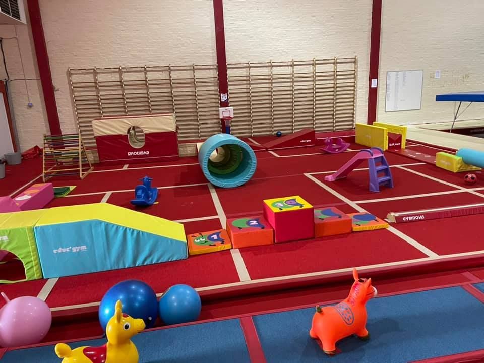 A gym with a bunch of toys on the floor.