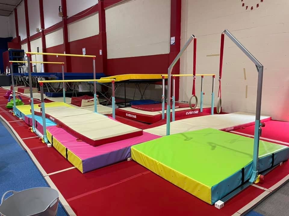 A gym with a lot of colorful mats and bars