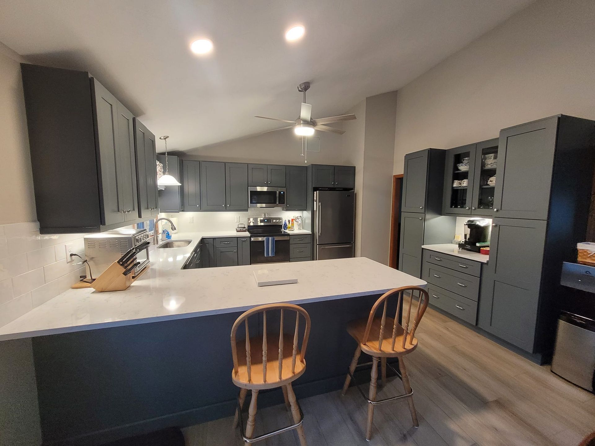 A kitchen with a large island and two chairs.