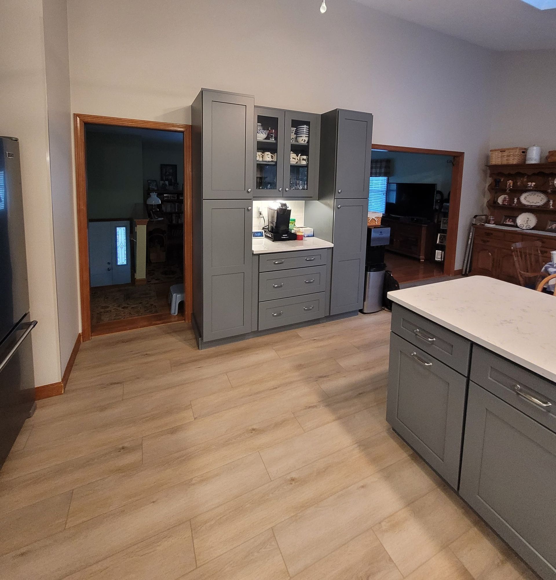 A kitchen with gray cabinets and a white counter top