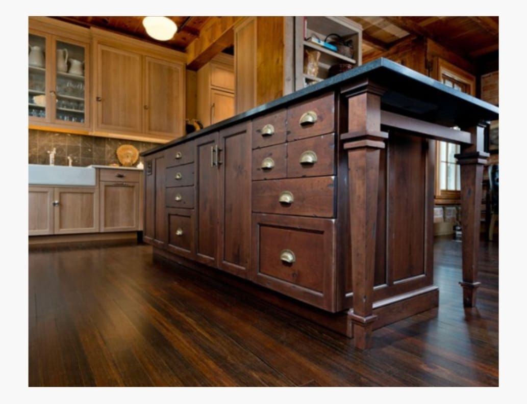 A kitchen with wooden cabinets and drawers and a large island