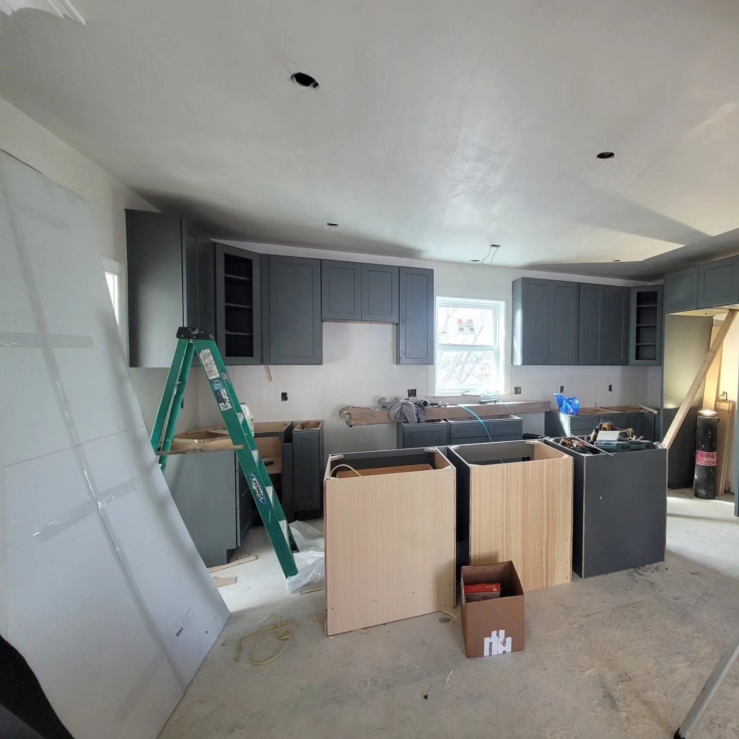 A kitchen under construction with a ladder and a box that says ma