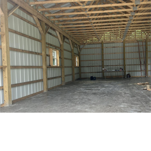 A large empty barn with a wooden roof and walls.