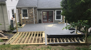 A wooden deck is being built in front of a house.