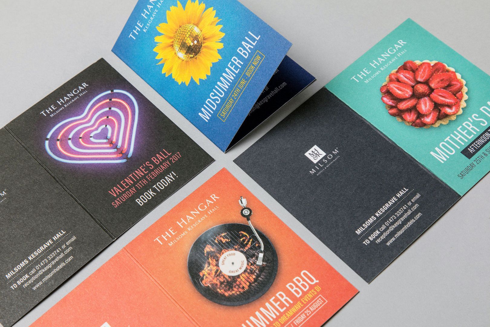 Four folded promotional flyers featuring event-themed images: neon heart, sunflower, strawberry tart, and record.