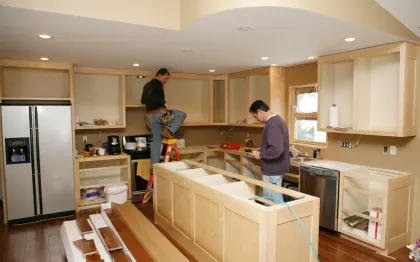 Israel Inc. - Two men are working on a kitchen in a house