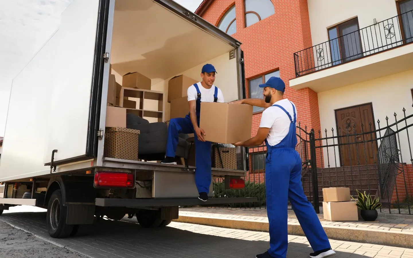 Two men are loading boxes into a moving truck.