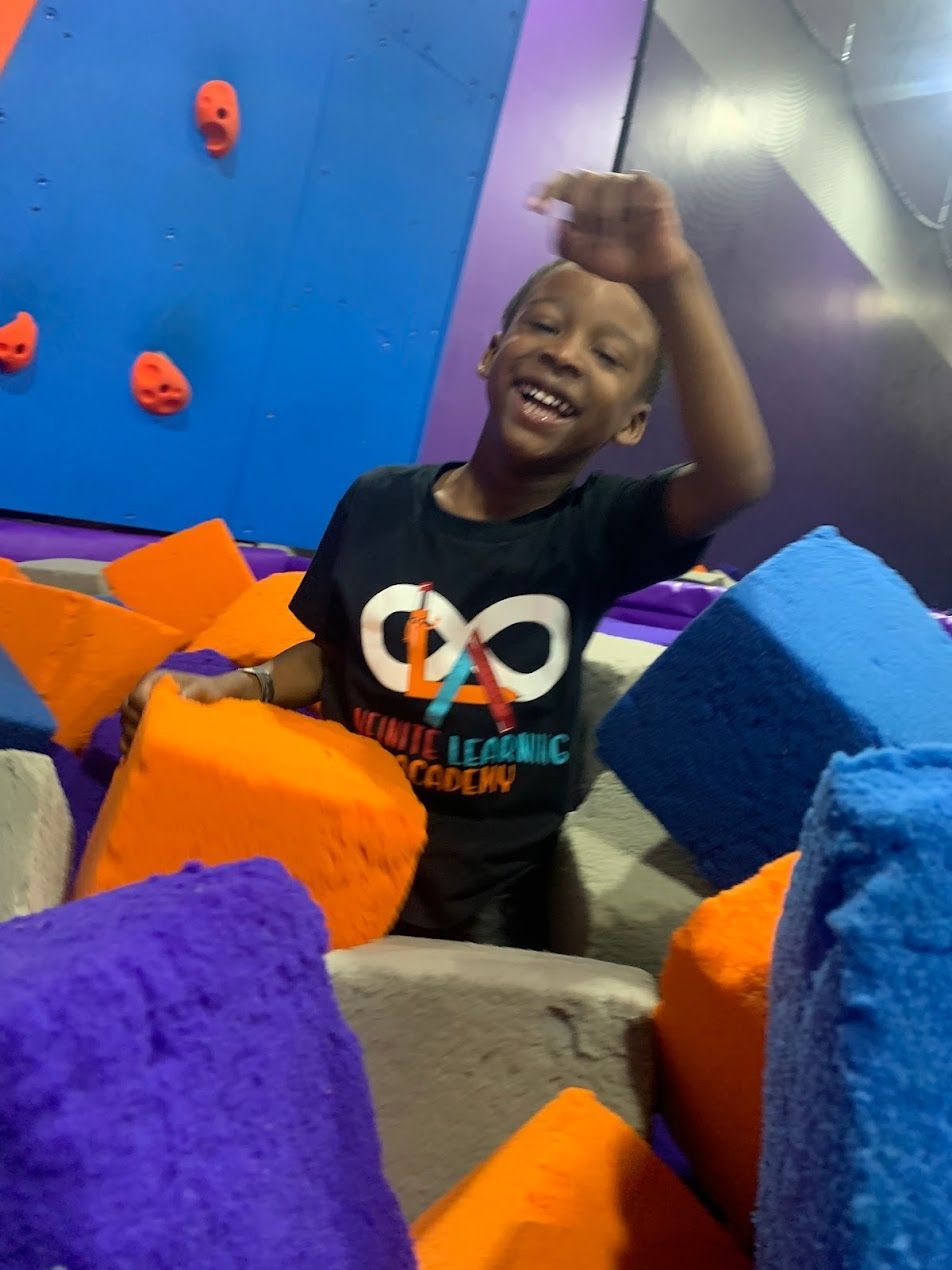 A young boy wearing a shirt that says infinite imagination follow