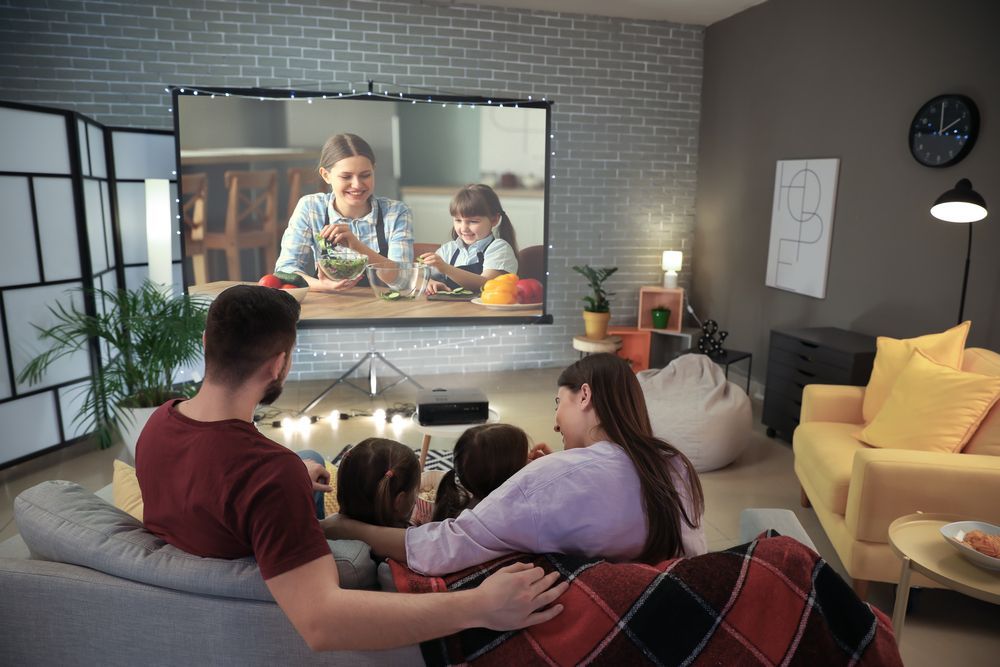 A Family Is Sitting on A Couch Watching a Movie on A Projector Screen — A1 Antenna Doctor In Port Macquarie, NSW
