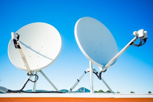 Two Satellite Dishes Are Sitting on A Rooftop Against a Blue Sky — A1 Antenna Doctor In Port Macquarie, NSW