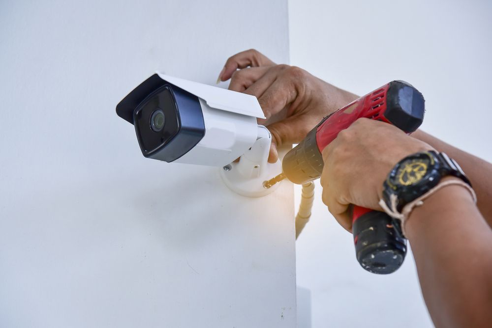 A Person is Installing a Security Camera on a Wall — A1 Antenna Doctor In Port Macquarie, NSW