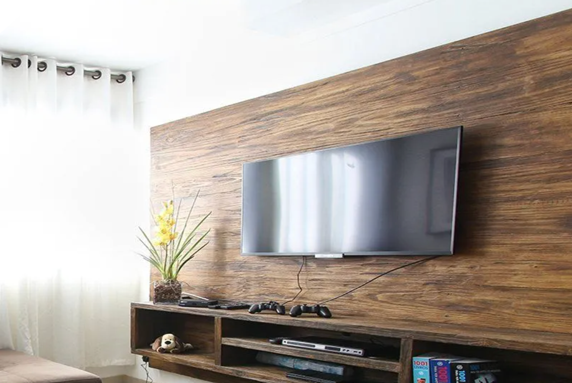 Flat screen TV mounted on a wooden wall.
