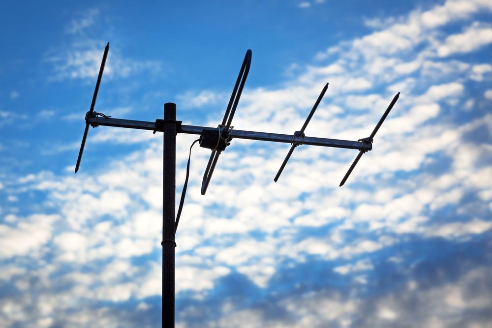 A Black Antenna Against a Blue Sky With Clouds — A1 Antenna Doctor In Port Macquarie, NSW