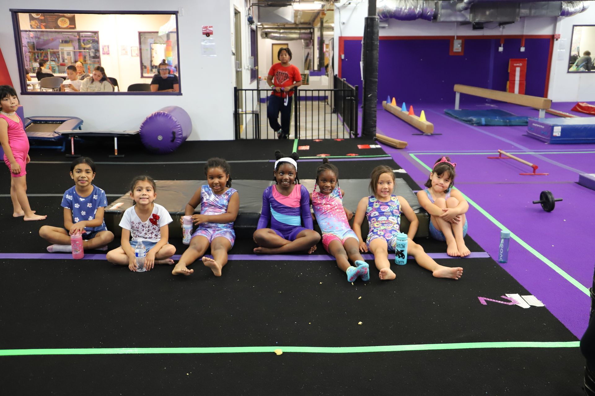 A gym filled with lots of equipment and a purple floor.