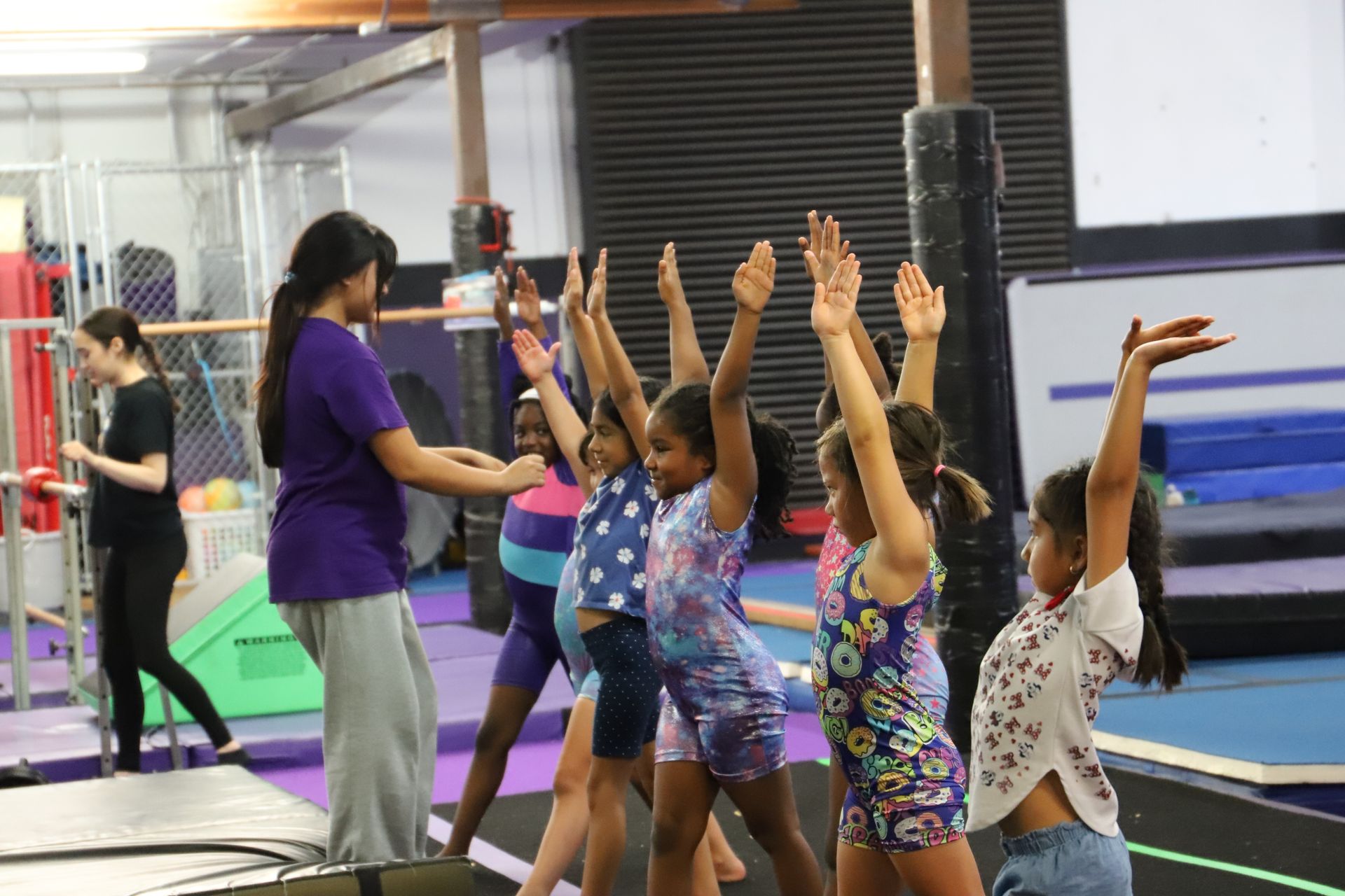 A group of female gymnasts are standing on a balance beam