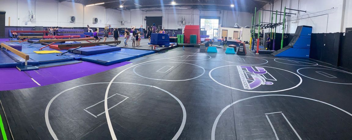 A large gym filled with lots of equipment and a basketball court.