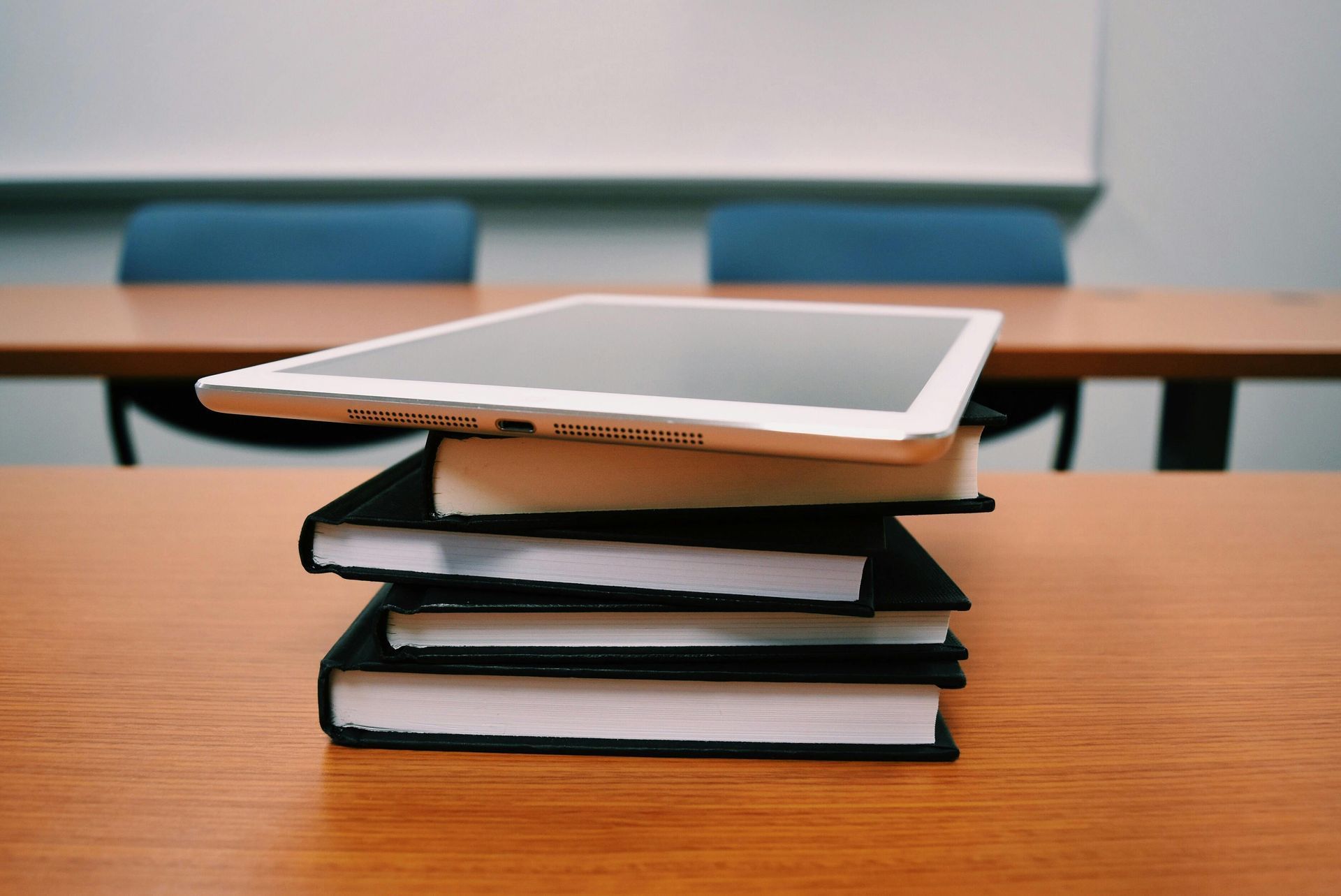 A tablet is sitting on top of a stack of books