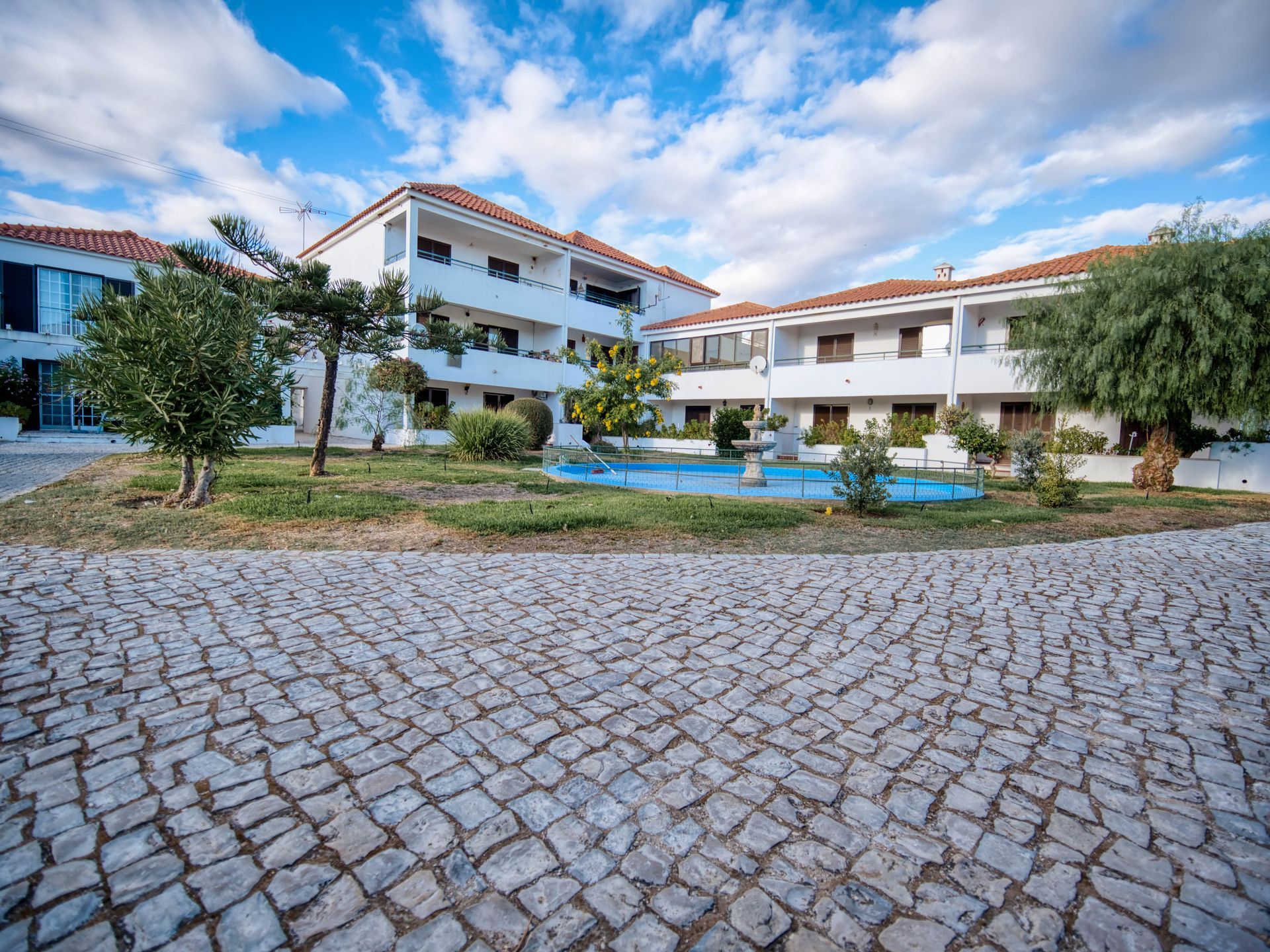Uma sala de estar com um sofá, cadeiras e uma mesa de centro.
