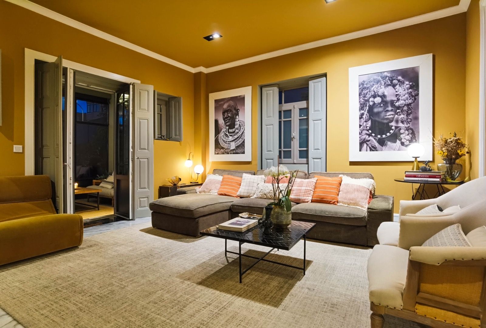 Uma sala de estar com um sofá, cadeiras e uma mesa de centro.