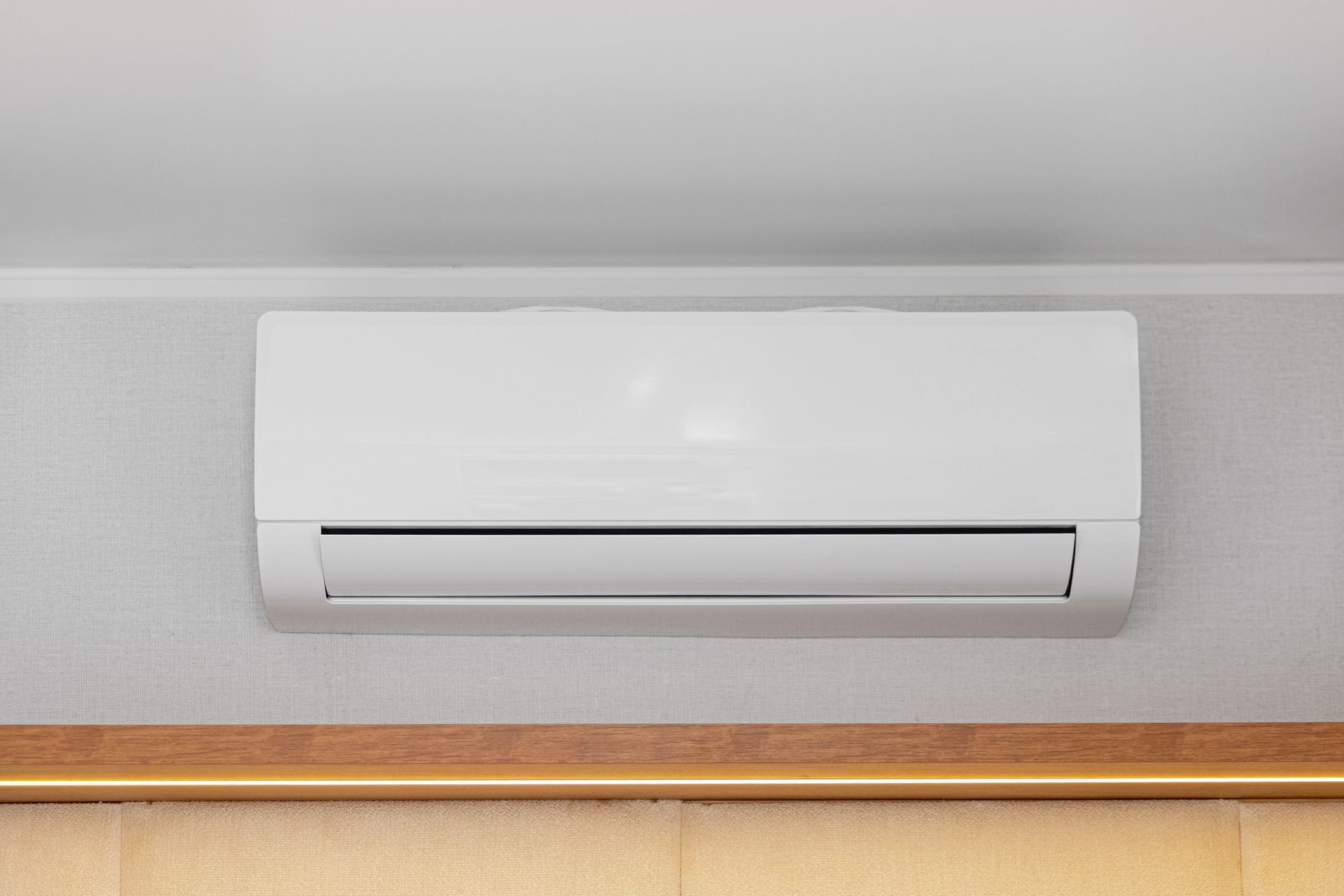 White Mini Split Air Conditioner Mounted on Wall in Room.