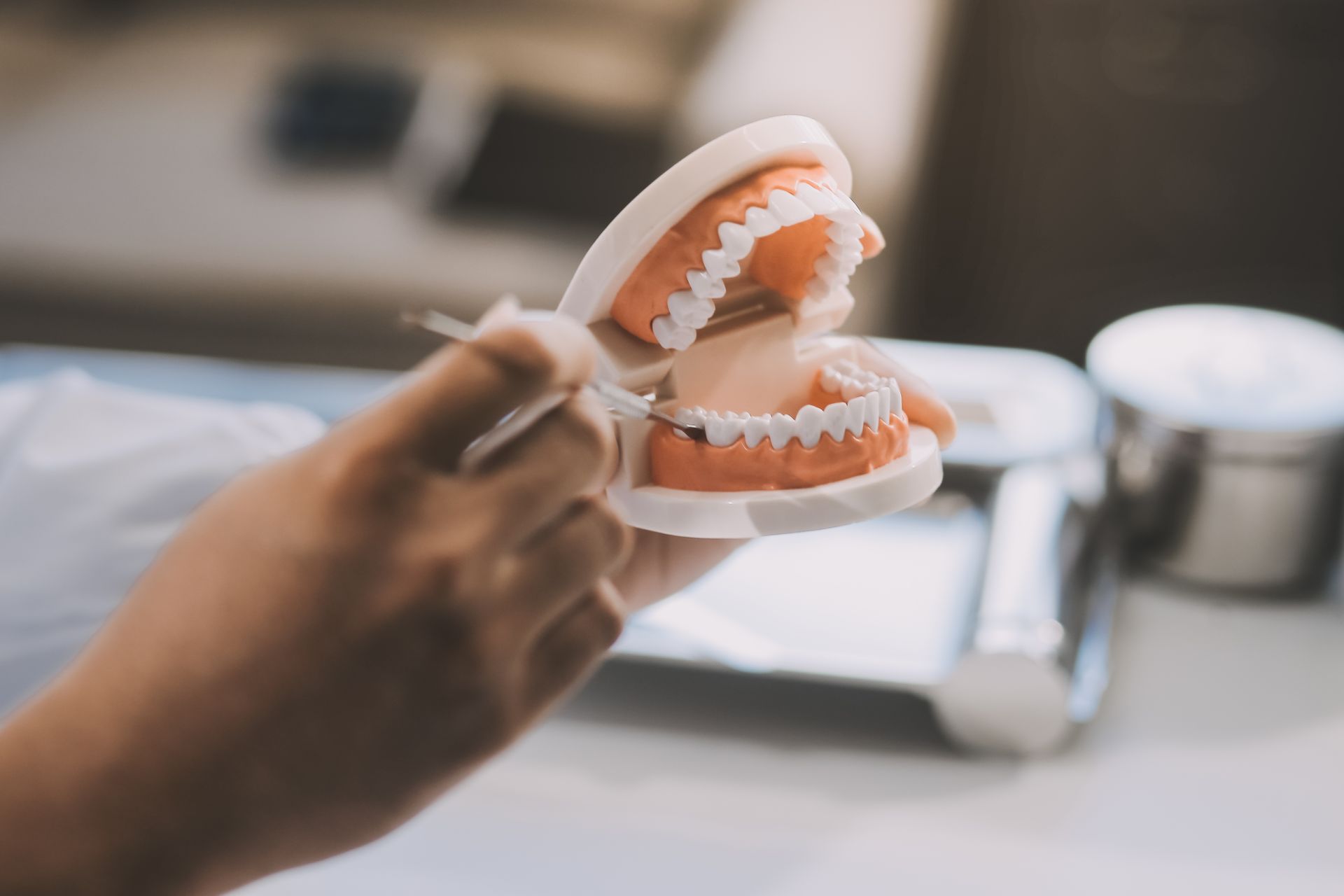Hand Holding a Dental Model Open With a Metal Tool — AB Esthetic Dental Laboratory in Robina, QLD