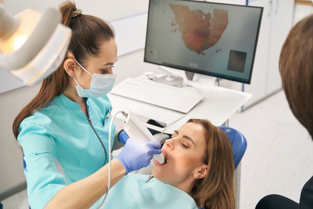 Dentist examining patient's mouth with a scanner in a dental office; monitor displaying the scan. — AB Esthetic Dental Laboratory in Sunshine Coast, QLD