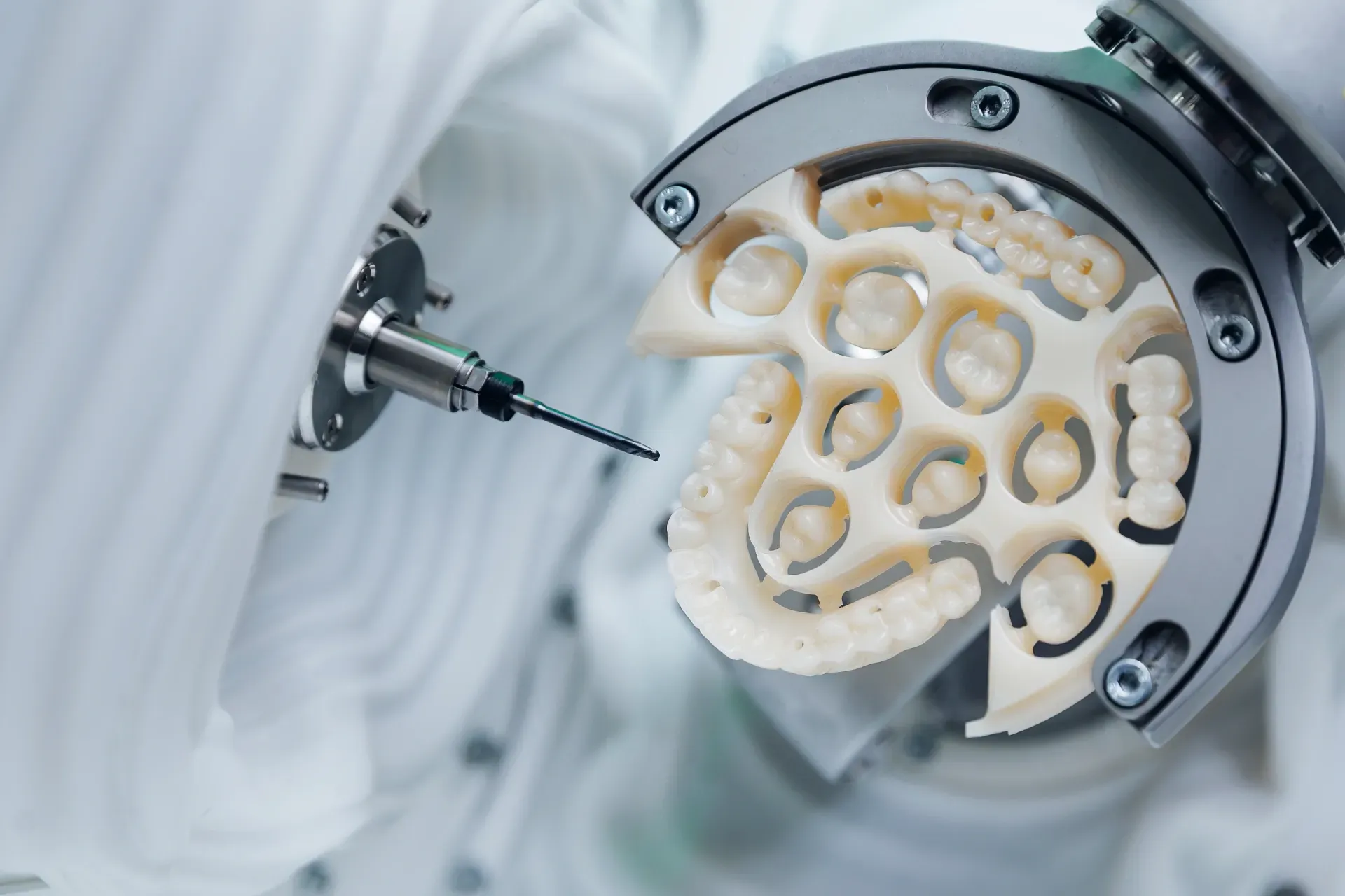 A dental milling machine crafting ceramic teeth replacements. — AB Esthetic Dental Laboratory in Robina, QLD