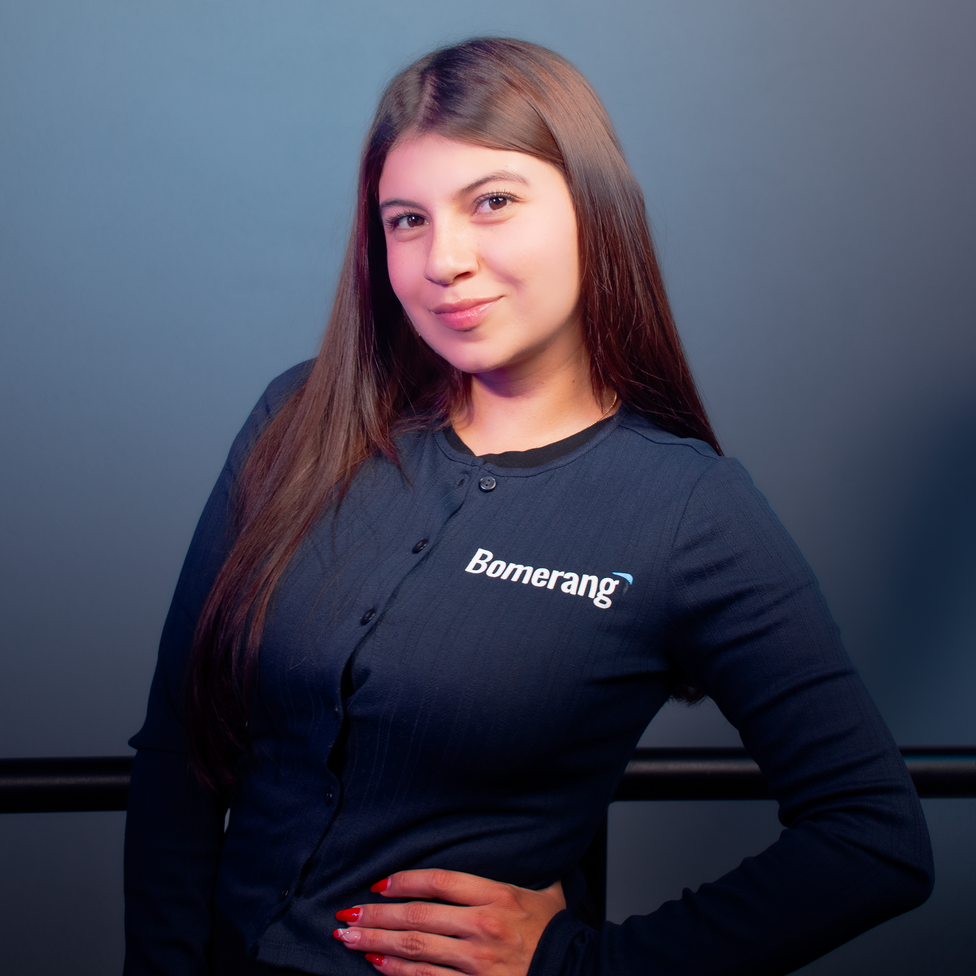 Una mujer que lleva una camiseta de bumerán está de pie con la mano en la cadera.
