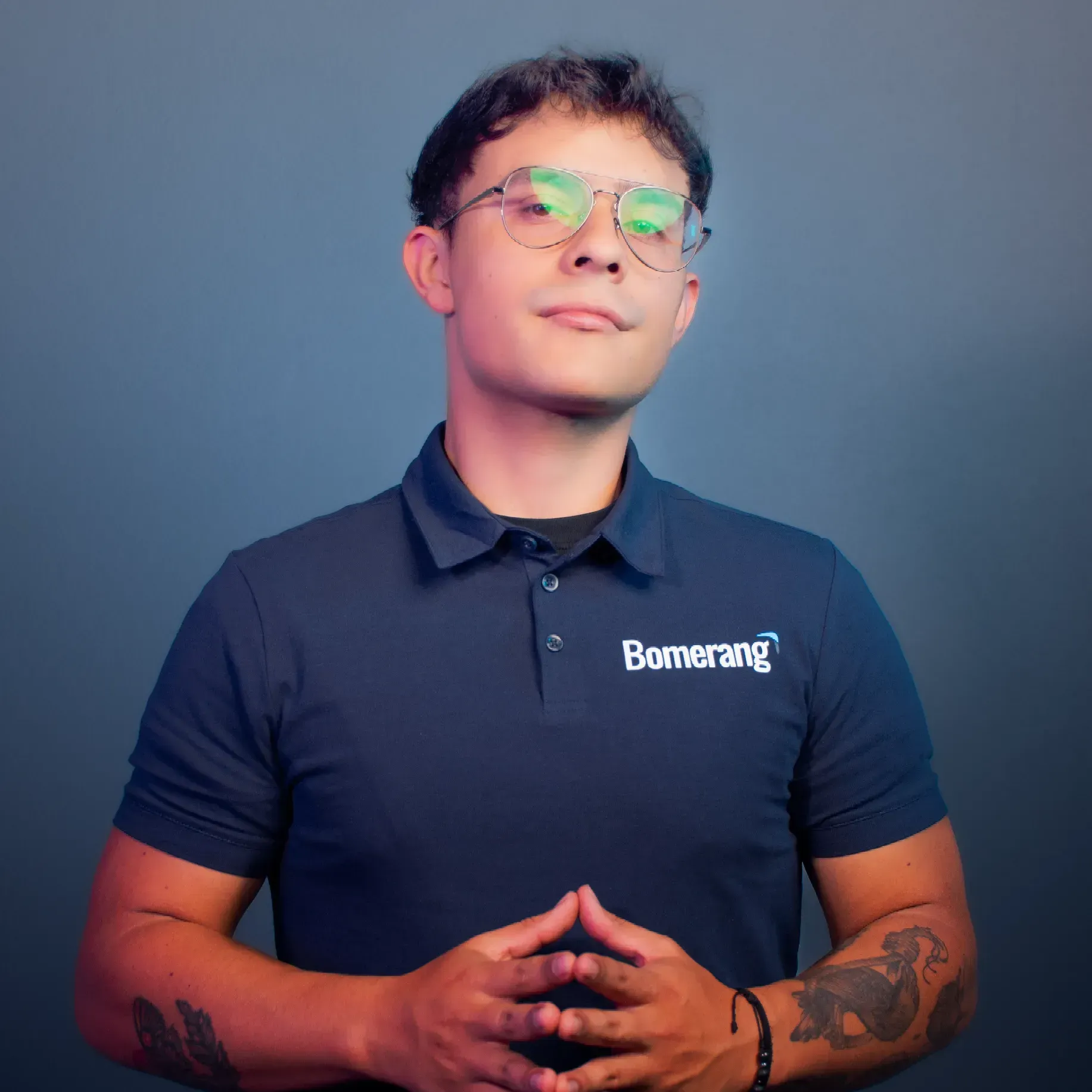 Hombre con gafas y polo azul marino con el logo 