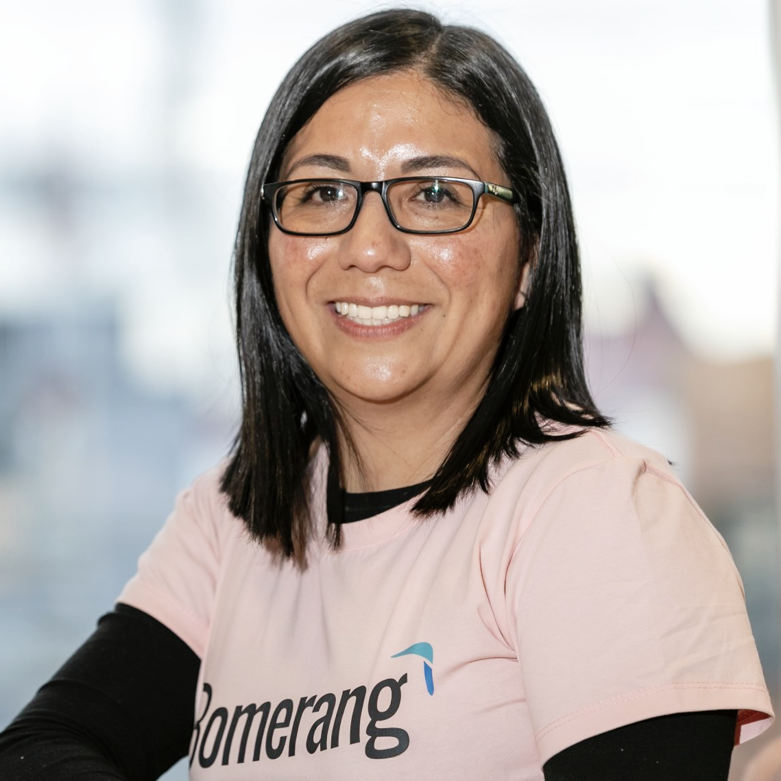 Una mujer con gafas y una camiseta rosa que dice boomerang.