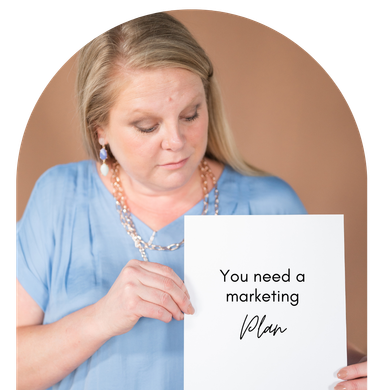 A woman is holding a piece of paper that says you need a marketing plan