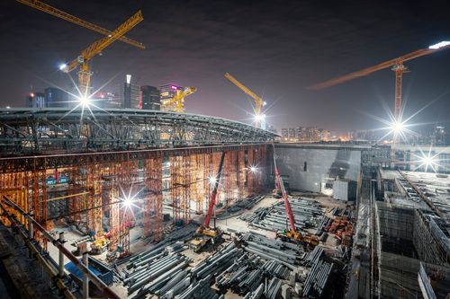A Large Building Is Being Built At Night With Cranes - Millville, CA - Concrete Construction Excavating Inc.