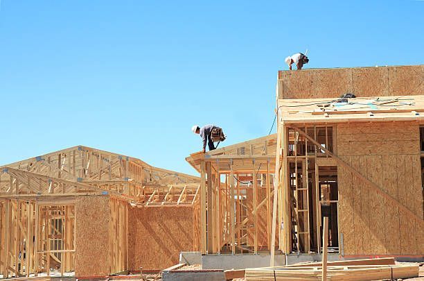 A Group Of Construction Workers Are Working On The Roof Of A House Under Construction - Millville, CA - Concrete Construction Excavating Inc.