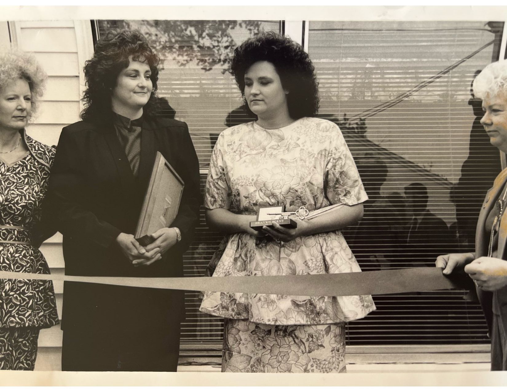 Two women standing in front of a sign for heaven scent flowers and gifts