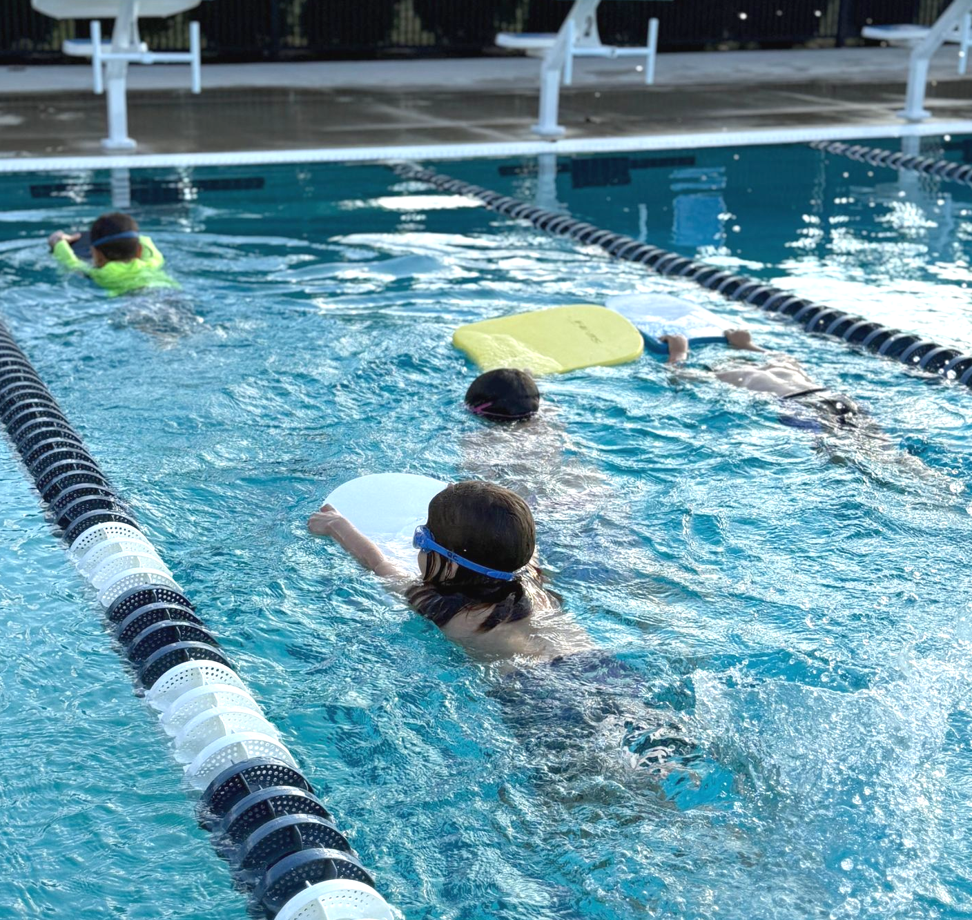 A woman is swimming in a swimming pool.