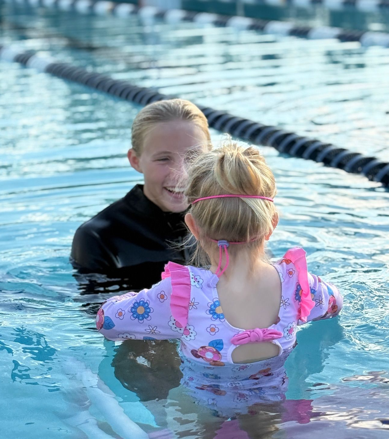 A group of children are swimming in a swimming pool.