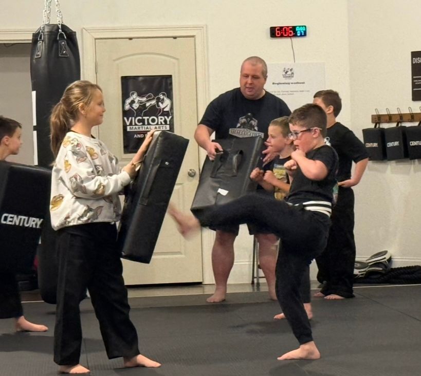 Children in karate uniforms practicing in a dojo.