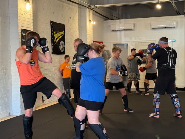 People practicing kickboxing in a gym. People practicing kickboxing in a gym.