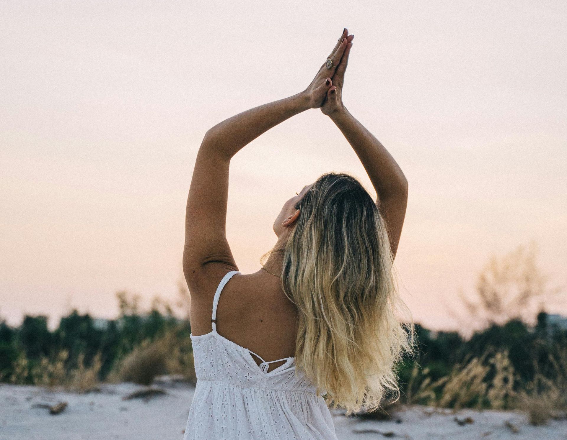 Frau am Strand, meditiert, Yoga, glücklich, friedlich 