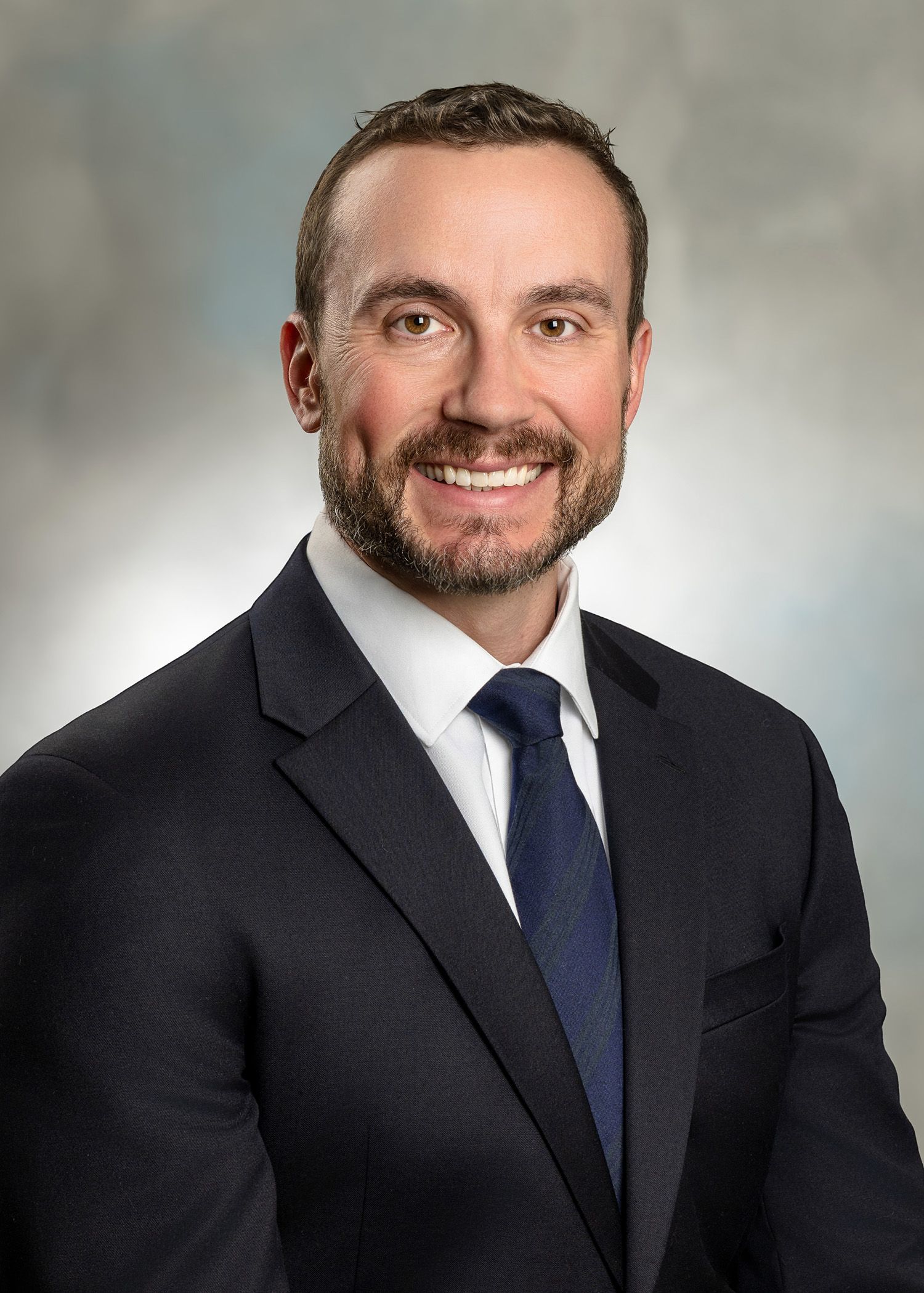 A man in a suit and tie is smiling for the camera.